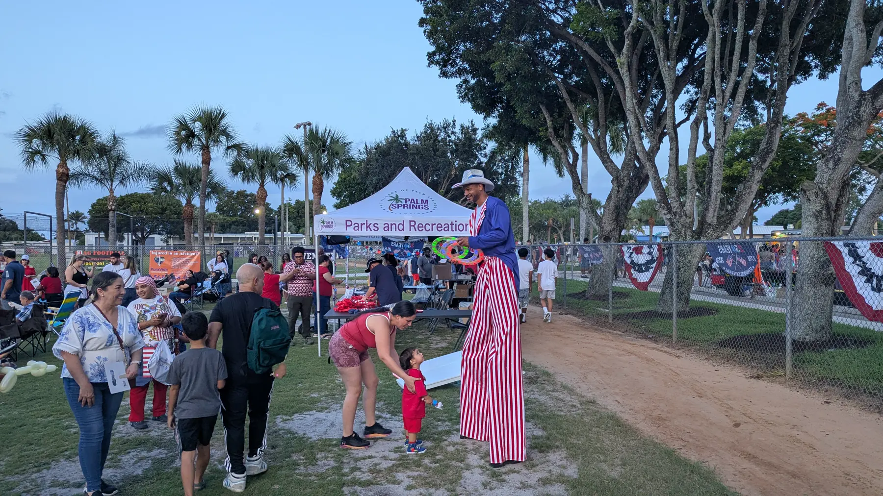 Parks and Recreation tent with stilt entertainer at the Village of Palm Springs 4th of July