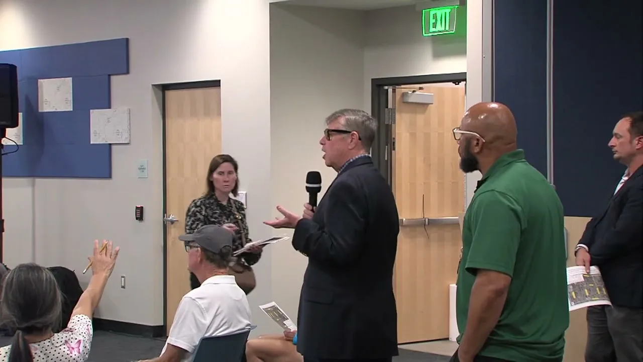 City staff answering a resident’s question with a handheld microphone at the Boynton Beach Miner Road Town Hall