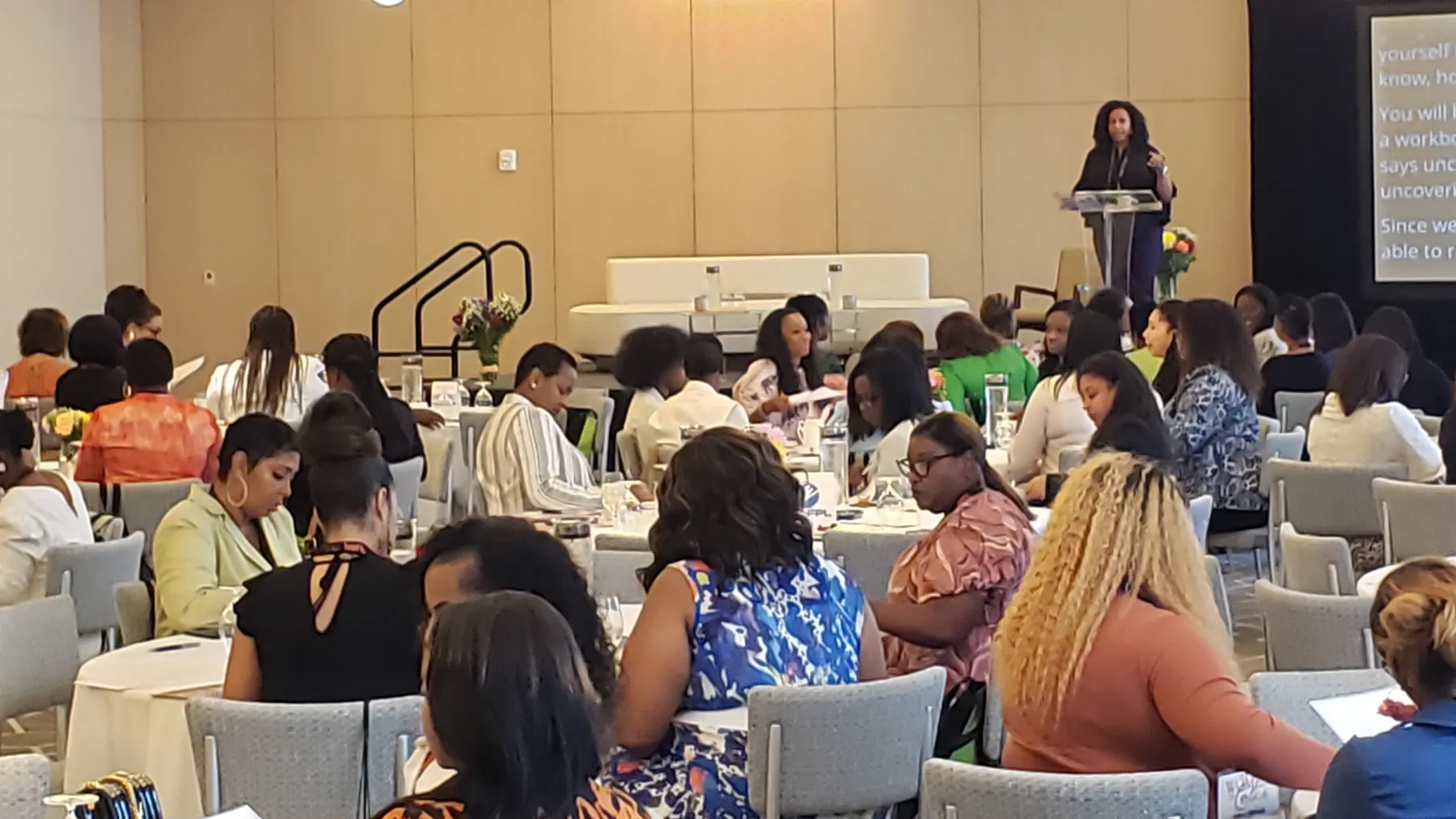 Speaker at the podium addressing the Women of Color Empowerment Conference