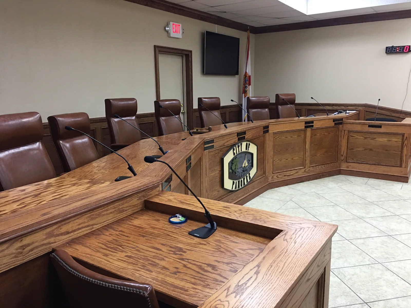 Municipal council chamber with a wood dais and public-meeting microphones