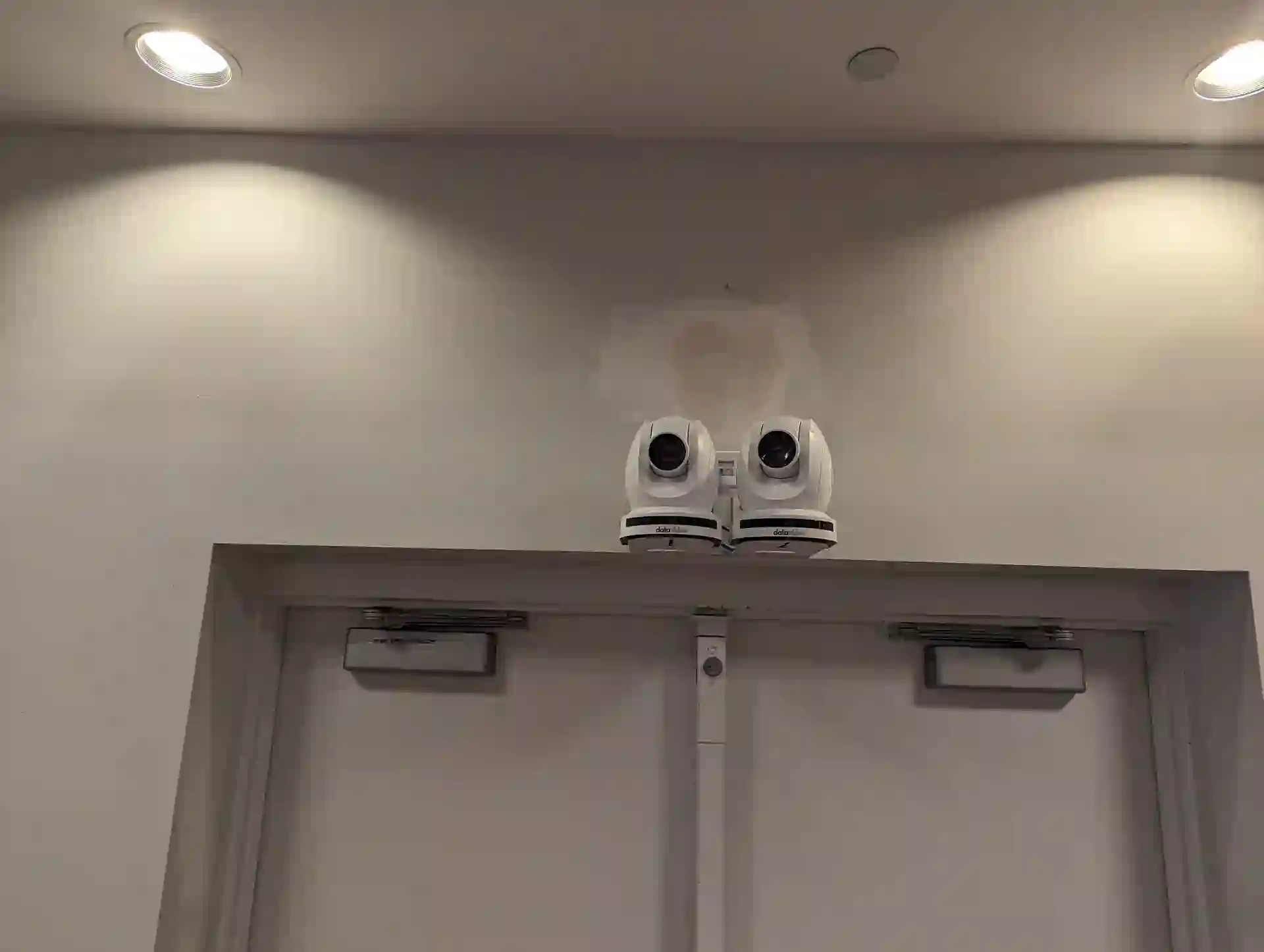 Close-up of two Datavideo 4K PTZ cameras installed above the chamber entrance